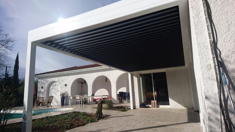 Een vakantiewoning voorzien van een terrasoverkapping met lamellendak