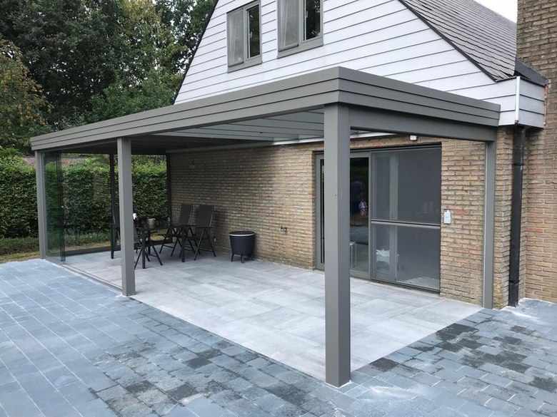 Een terrasoverkapping met plat dak waar glas en dakpanelen gecombineerd zijn 